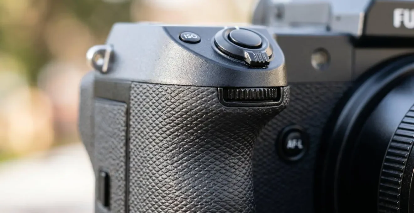 Gros plan sur la poignée ergonomique noire d'une caméra de poing professionnelle avec ses boutons de contrôle tactiles